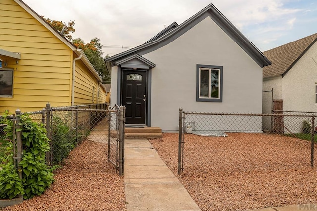 entrance to property with fence and stucco siding