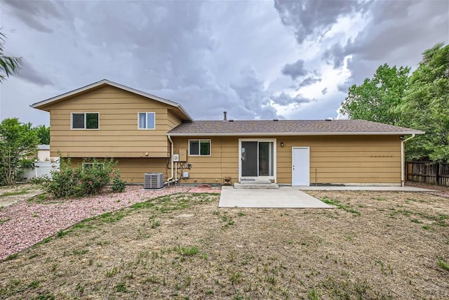 rear view of property featuring fence, central AC, and a patio area