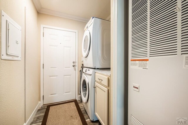999 Fortino Blvd Unit 33, Pueblo, CO 81008 - laundry area with electric panel, a heating unit, cabinet space, stacked washer and clothes dryer, and crown molding