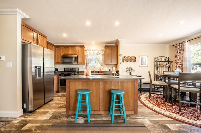 999 Fortino Blvd Unit 33, Pueblo, CO 81008 - kitchen featuring baseboards, ornamental molding, wood finished floors, and stainless steel appliances