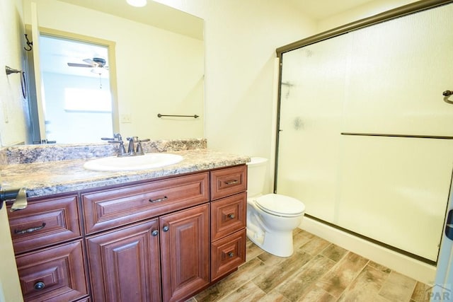1781 N Billy The Kid Ln, Pueblo, CO 81007 - bathroom featuring vanity, a stall shower, toilet, and wood finished floors
