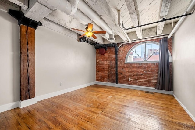 201 Lamkin St Unit 207, Pueblo, CO 81003 - empty room featuring hardwood / wood-style flooring, brick wall, and a ceiling fan