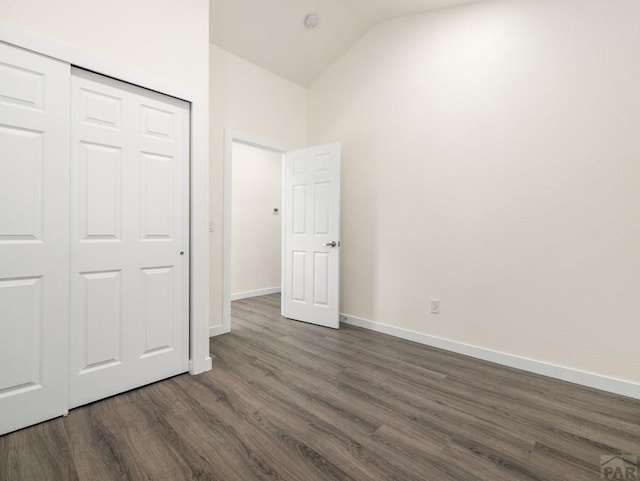 906 E 6th St, Pueblo, CO 81001 - unfurnished bedroom with dark wood-style flooring, lofted ceiling, and a closet