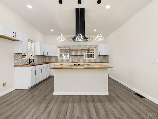 906 E 6th St, Pueblo, CO 81001 - kitchen featuring butcher block counters, open shelves, a center island, tasteful backsplash, and recessed lighting
