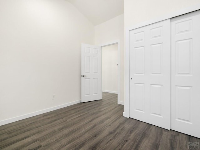 906 E 6th St, Pueblo, CO 81001 - unfurnished bedroom with lofted ceiling, dark wood-type flooring, and a closet