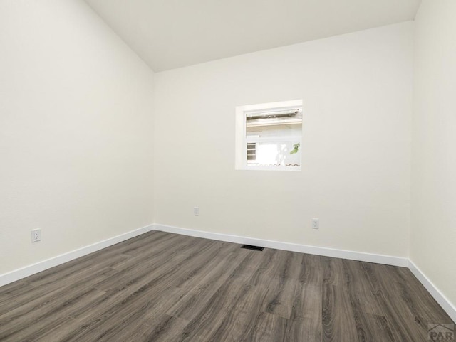 906 E 6th St, Pueblo, CO 81001 - unfurnished room with dark wood-style flooring and vaulted ceiling