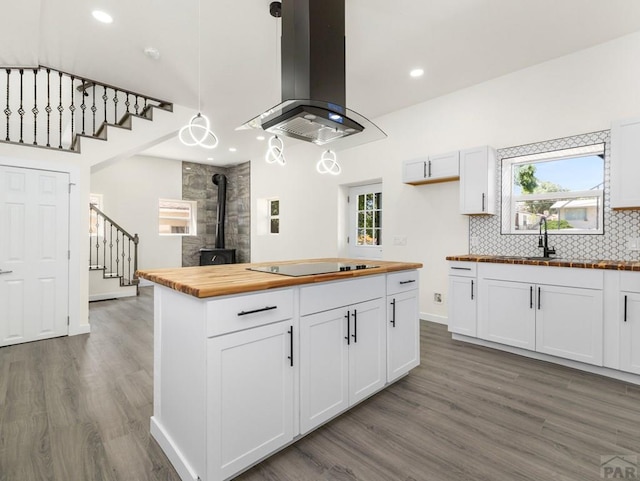 906 E 6th St, Pueblo, CO 81001 - kitchen featuring butcher block countertops, island range hood, black electric cooktop, wood finished floors, and recessed lighting