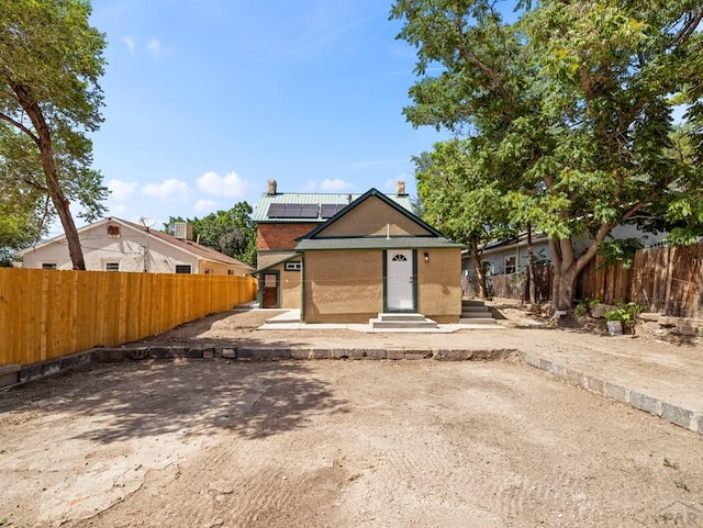 906 E 6th St, Pueblo, CO 81001 - view of front of house with solar panels, a chimney, and entry steps