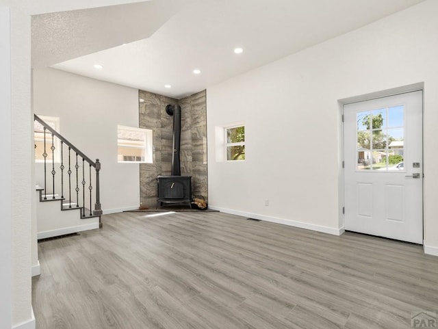 906 E 6th St, Pueblo, CO 81001 - unfurnished living room with wood finished floors, stairs, recessed lighting, and a wood stove