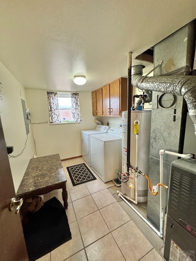 washroom with gas water heater, light tile patterned floors, cabinet space, a textured ceiling, and washer and dryer