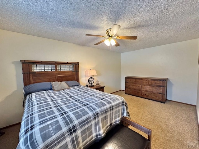 bedroom with carpet floors, a textured ceiling, baseboards, and a ceiling fan