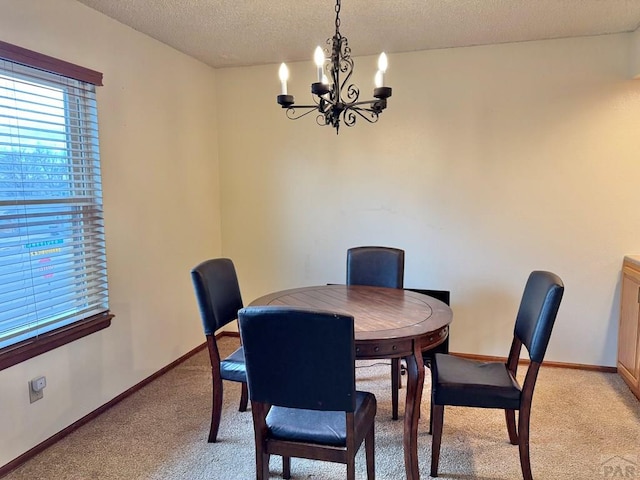 dining space with light carpet, a textured ceiling, baseboards, and an inviting chandelier