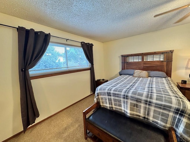 bedroom featuring carpet, baseboards, and a textured ceiling