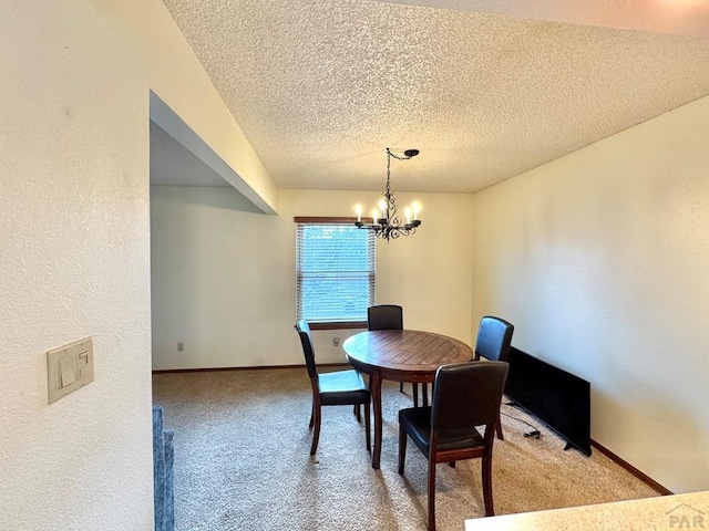 carpeted dining room with baseboards, a textured ceiling, and a notable chandelier