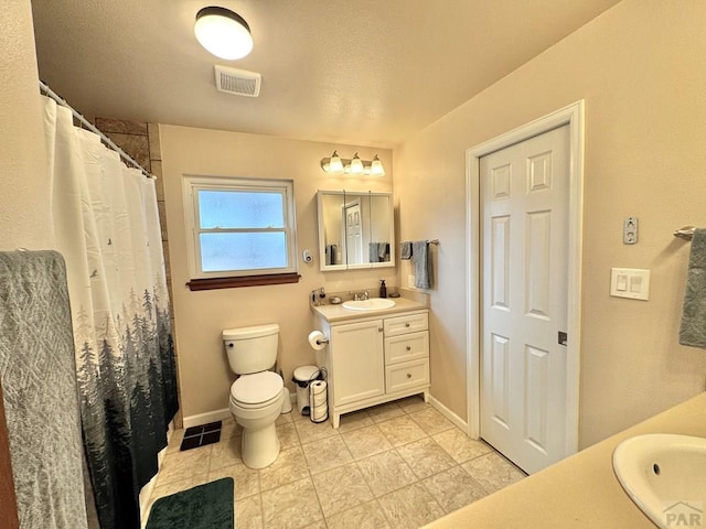 bathroom featuring toilet, baseboards, visible vents, and vanity