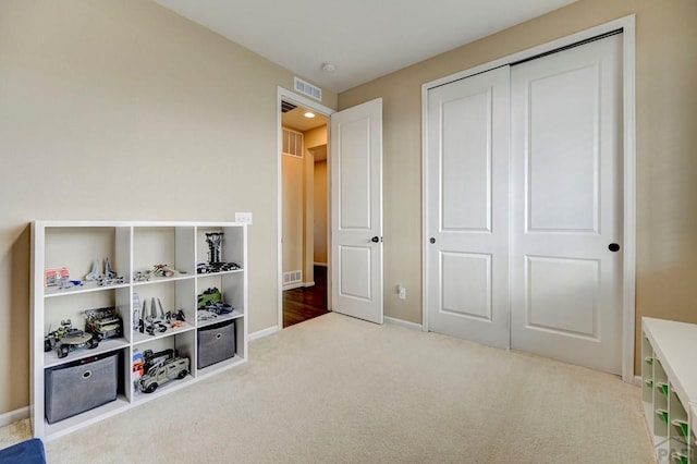 recreation room featuring baseboards, visible vents, and carpet flooring