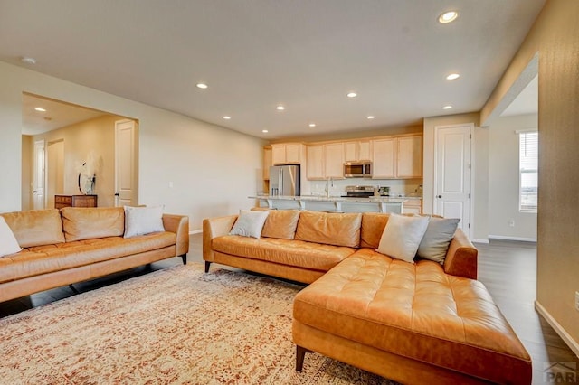 living area featuring recessed lighting, baseboards, and wood finished floors