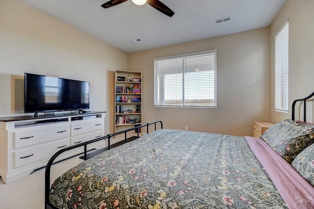 carpeted bedroom featuring visible vents and a ceiling fan