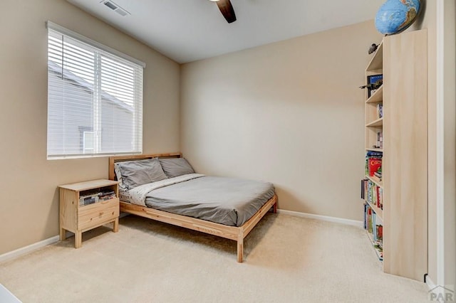 bedroom with baseboards, visible vents, a ceiling fan, and light colored carpet