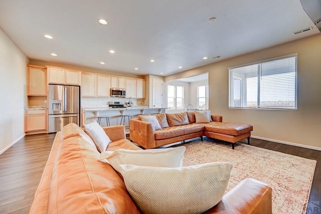 living area featuring visible vents, wood finished floors, and recessed lighting