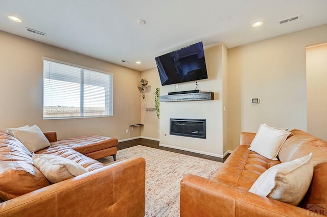 living area with recessed lighting, visible vents, wood finished floors, and a glass covered fireplace