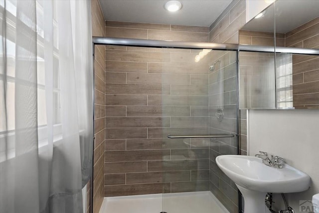 full bath featuring a stall shower and a sink