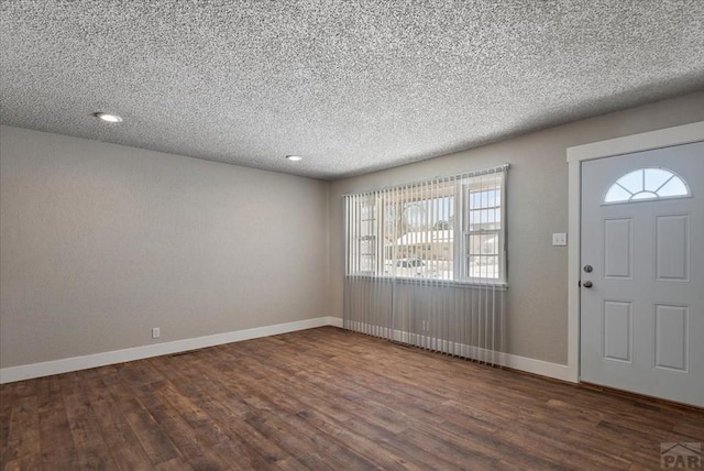 entrance foyer featuring a textured ceiling, baseboards, and dark wood-type flooring