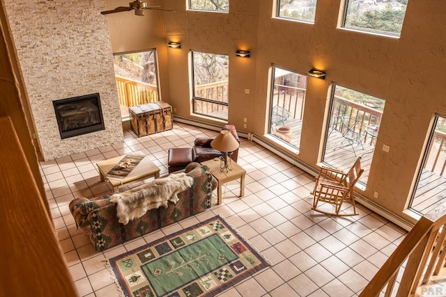 109 County Rd 405, Cuchara, CO 81055 - tiled living area featuring ceiling fan, a fireplace, a towering ceiling, and a baseboard heating unit