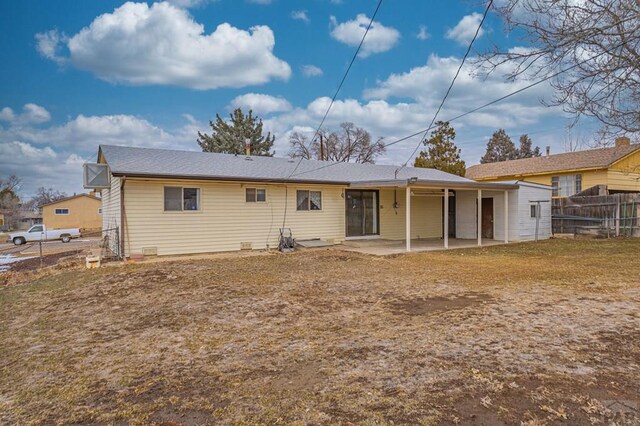 rear view of house with a yard, fence, and a patio