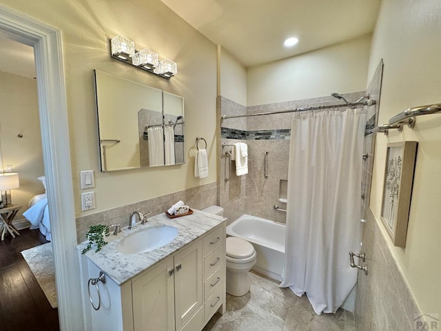 ensuite bathroom with ensuite bathroom, toilet, shower / bath combo, and vanity