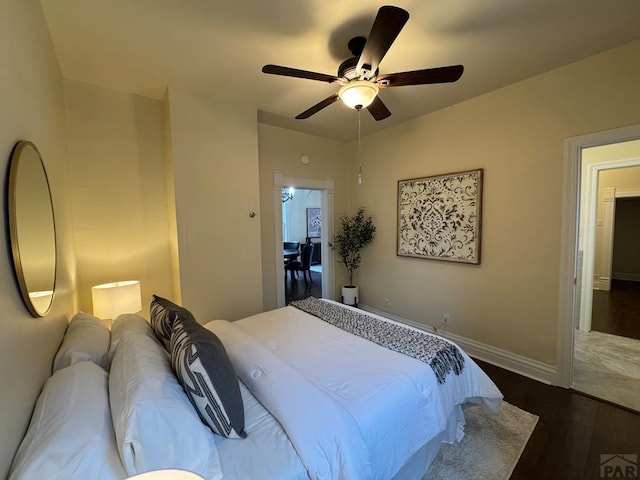 bedroom with ceiling fan, baseboards, and dark wood-type flooring