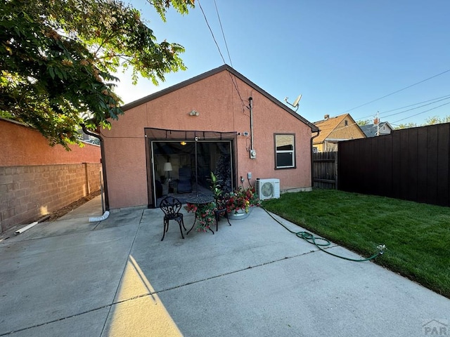 rear view of house with a patio area, a fenced backyard, a yard, ac unit, and stucco siding