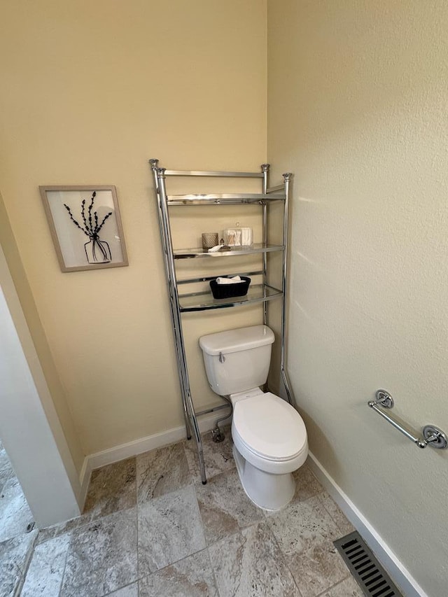 bathroom featuring toilet, baseboards, and visible vents