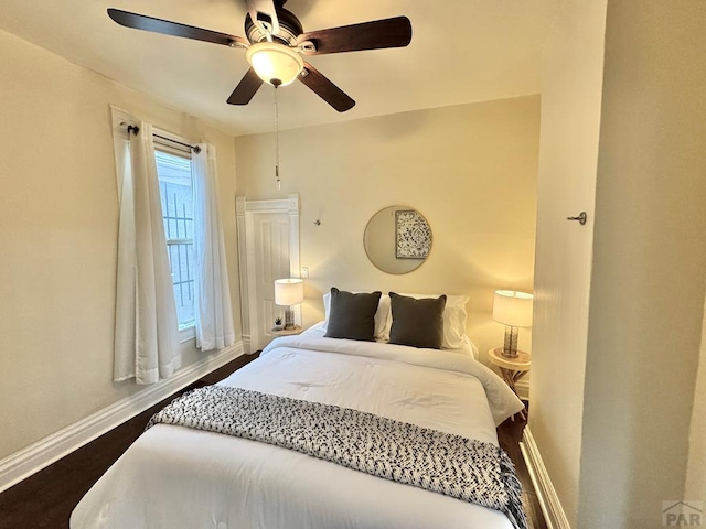 bedroom with baseboards, dark wood-type flooring, and a ceiling fan