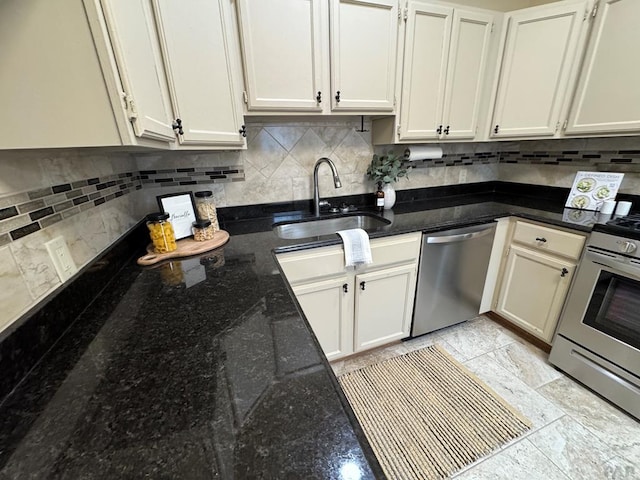 kitchen featuring dark stone counters, appliances with stainless steel finishes, a sink, and tasteful backsplash