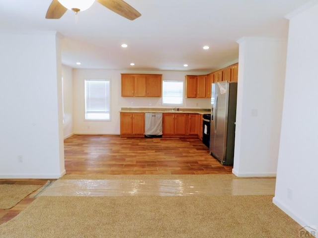 kitchen with light wood-style flooring, recessed lighting, stainless steel appliances, open floor plan, and light countertops