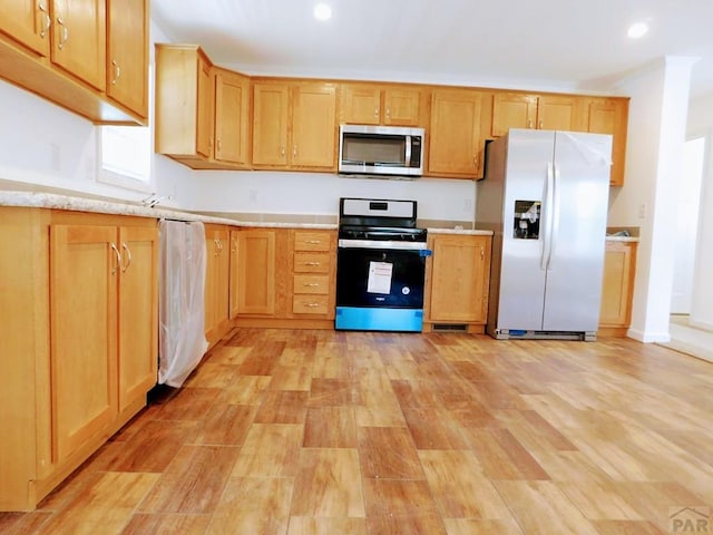 kitchen featuring stainless steel appliances, light wood-type flooring, light countertops, and recessed lighting