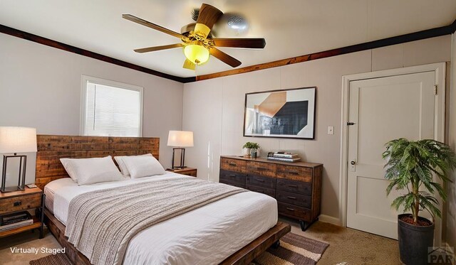 bedroom with carpet floors, ornamental molding, and a ceiling fan