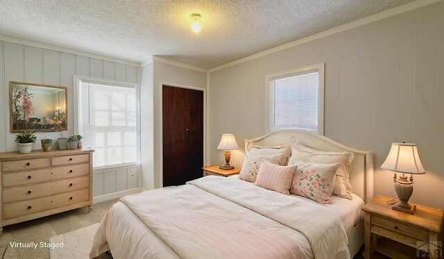 bedroom featuring crown molding, a textured ceiling, and light colored carpet