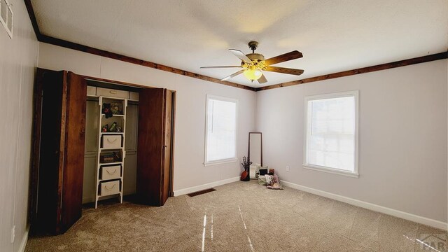 unfurnished bedroom with visible vents, baseboards, a ceiling fan, carpet, and a closet