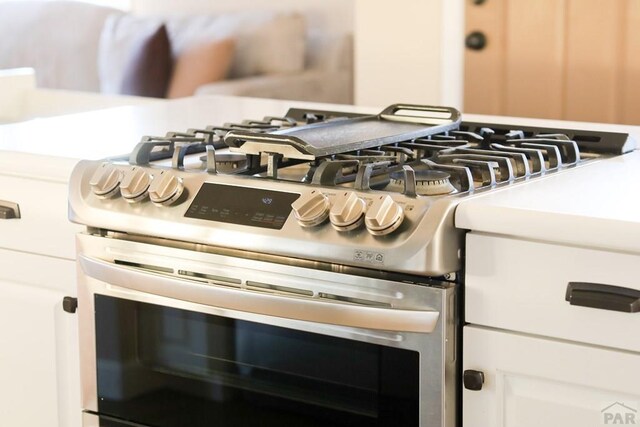 interior details featuring gas stove and light countertops