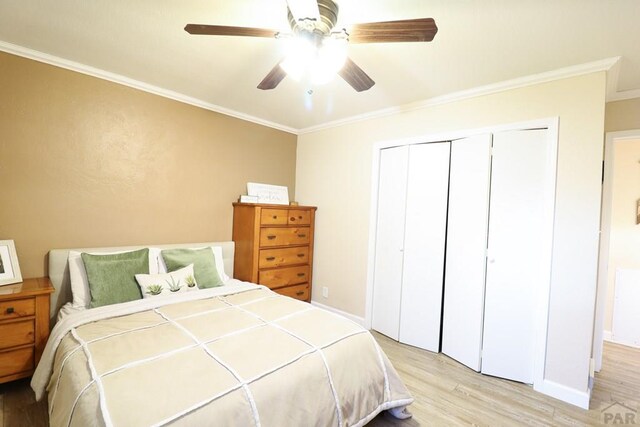 bedroom featuring light wood-style floors, a closet, crown molding, and ceiling fan