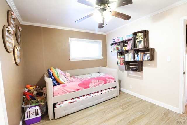 bedroom featuring light wood finished floors, ornamental molding, a ceiling fan, and baseboards