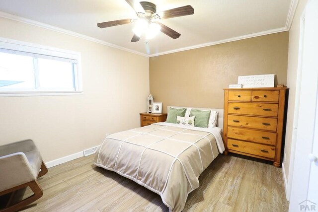 bedroom featuring light wood-type flooring, baseboards, and ornamental molding