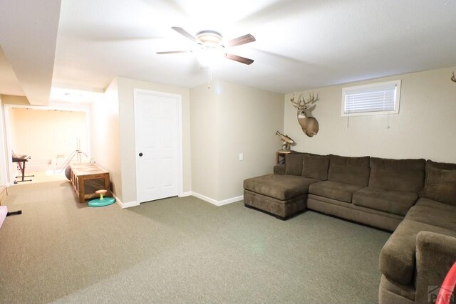 carpeted living area with ceiling fan and baseboards