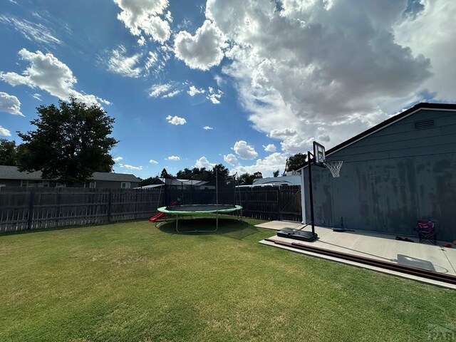 view of yard featuring a fenced backyard and a trampoline