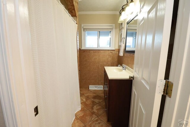 full bath with visible vents, ornamental molding, tile patterned floors, vanity, and tile walls