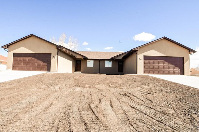 single story home featuring concrete driveway, an attached garage, and stucco siding