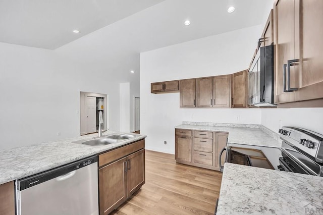 kitchen featuring appliances with stainless steel finishes, a sink, light wood-style flooring, and recessed lighting