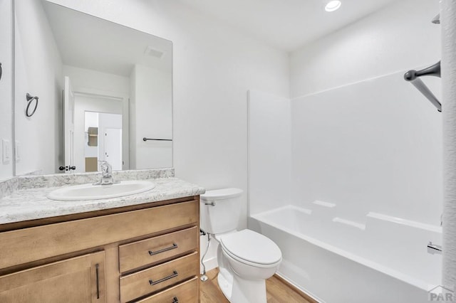 bathroom with shower / tub combination, toilet, wood finished floors, visible vents, and vanity